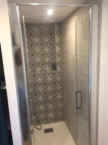 a shower with a glass door in a bathroom at La maison de Gwen in Cléden-Cap-Sizun