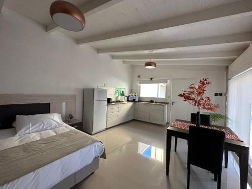 een slaapkamer met een bed en een tafel en een keuken bij Cabaña de los Colibríes in Esquel