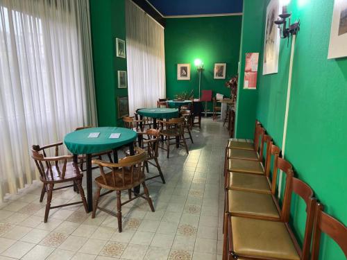 een restaurant met groene muren en tafels en stoelen bij Appartamento monolocale Fiuggi 14 MQ piscina dal 20 giugno al 15 settembre in Fiuggi