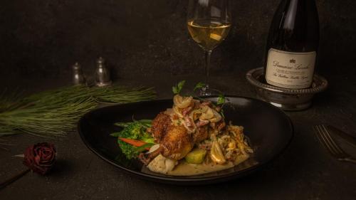 a plate of food on a table with a glass of wine at Merrill House in Picton