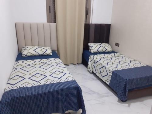 twee bedden in een kamer met blauwe en witte lakens bij Private, Air Conditionner and Free Parking in Fès