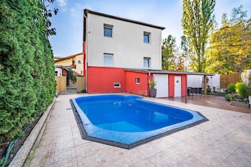 プラハにあるBáječné ubytování ve vile s bazénem a terasou.の家の前の青い大型スイミングプール