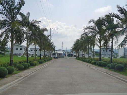 an empty street with palm trees and houses at TymCast's Place - 2 Story house in Kabankalan