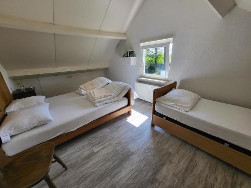 two beds in a room with a window at Boshoes in Heythuysen