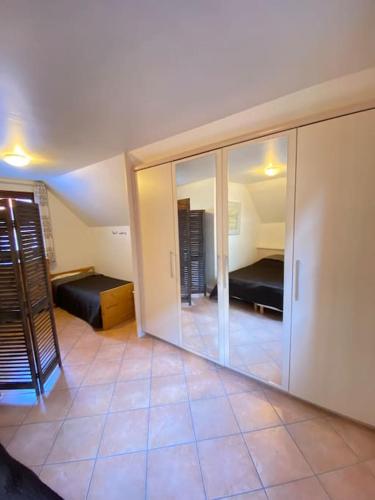 Habitación con 2 camas y espejo. en Le Riquewihrien en Riquewihr