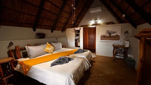 a bedroom with two beds in a room at Ohange Namibia Lodge in Otavi