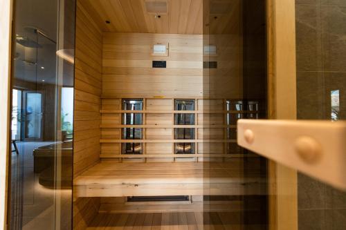 a bathroom with a shower with a wooden wall at Rókusfalvy Borhotel és Fogadó in Etyek