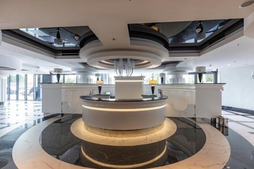 a large lobby with a circular fountain in the middle at Kaleo apartments - Hanza Tower in Szczecin