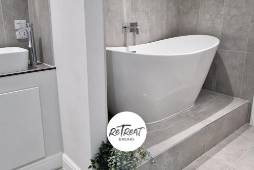a bathroom with a bath tub and a sink at ReTreat Breaks - 3 Bedroom Penthouse - Holbeck Leeds in Leeds