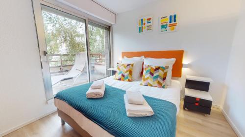 een slaapkamer met een groot bed en 2 handdoeken bij Maison Mandarine Colmar 5 bedrooms 180m2 in Colmar