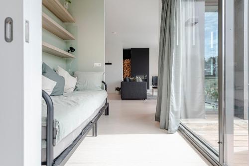 1 dormitorio con 1 cama y puerta corredera de cristal en Dune Villa 7 en Zandvoort