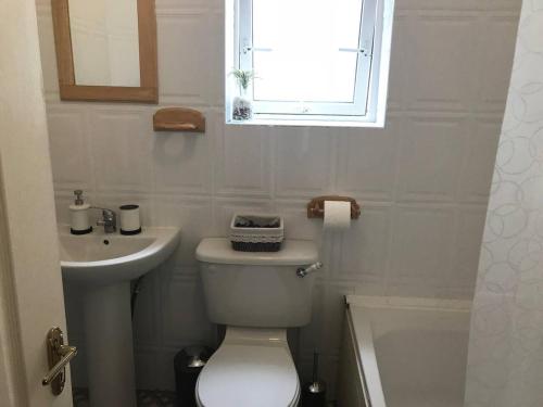 uma casa de banho com um WC, um lavatório e uma janela em Dublin Home by Clonsilla train 25min to City em Dublin