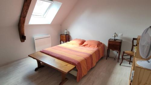 a bedroom with a bed and a skylight at Gîte de La Basse Roche in Sougé