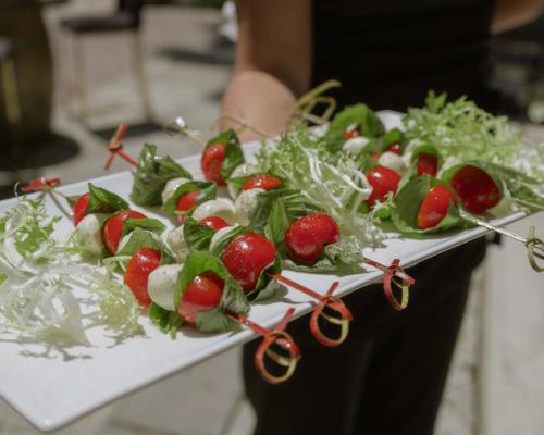 a person holding a tray of vegetables on a table at Merrill House in Picton