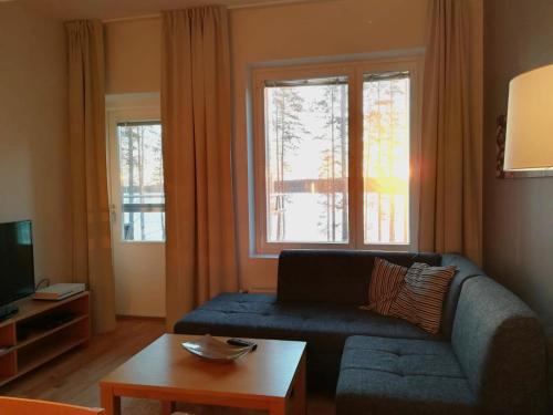 - un salon avec un canapé bleu et une fenêtre dans l'établissement Laatuhuoneisto Saimaa näkymällä- Luxury apartment by lake Saimaa, à Imatra