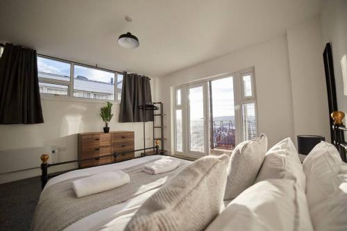 a bedroom with a bed with white sheets and a window at High Spec Spacious 2BD Apt, Parking, Nr Newcastle in Gateshead