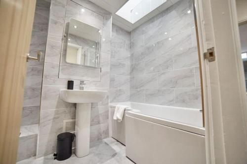 a bathroom with a sink and a tub and a mirror at High Spec Spacious 2BD Apt, Parking, Nr Newcastle in Gateshead