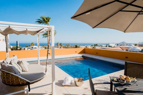 a hammock and an umbrella next to a swimming pool at Ocean view, pool & gated community in Cabo San Lucas