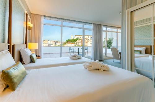 Olissippo Castelo في لشبونة: غرفة فندقية بسريرين ونافذة كبيرة