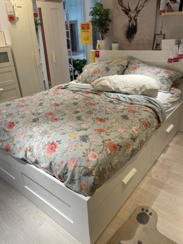 - un lit avec une couette à fleurs dans une chambre dans l'établissement شقة بالعجمي غرفتين, à Alexandrie