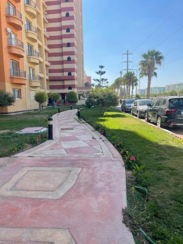 un trottoir à côté d'un bâtiment avec des voitures garées dans l'établissement شقة بالعجمي غرفتين, à Alexandrie