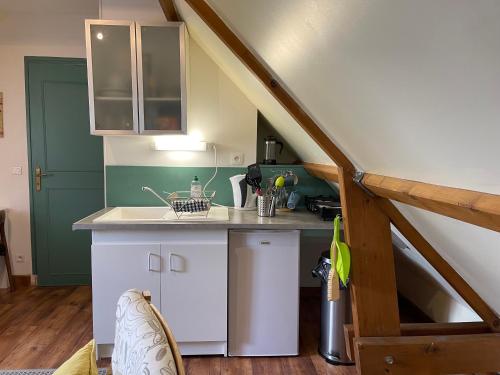 - une cuisine mansardée avec un évier et un comptoir dans l'établissement La Melerie, à Contres