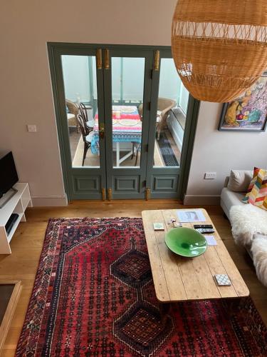 a living room with a coffee table and a view of a balcony at Pretty Cottage in Central Lewes in Lewes