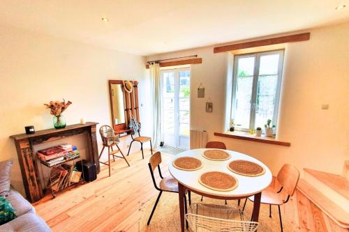 un salon avec une table et des chaises dans l'établissement Nice nest with garden in the city center, à La Gouesnière