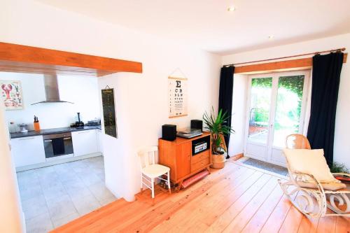 Il comprend une cuisine avec des murs blancs et du parquet. dans l'établissement Nice nest with garden in the city center, à La Gouesnière