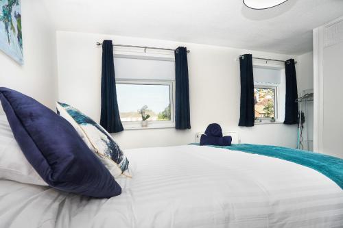 a bedroom with a large white bed with blue pillows at Springland Close in Ipswich