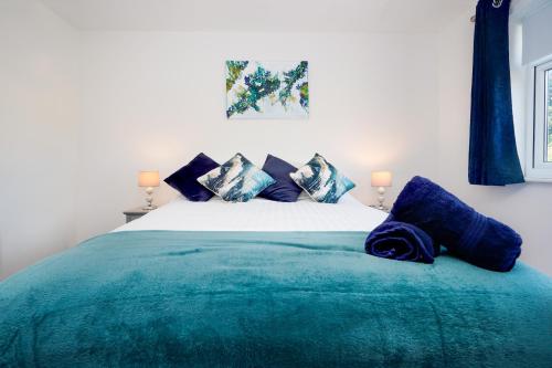 a bedroom with a large bed with blue pillows at Springland Close in Ipswich