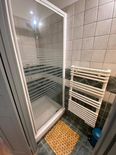 une douche avec une porte vitrée dans une salle de bain dans l'établissement Joli appartement cosy, à Arles
