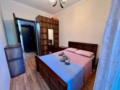 ein Schlafzimmer mit einem großen Bett mit einer blauen Decke in der Unterkunft Apartment in the city in Kutaissi