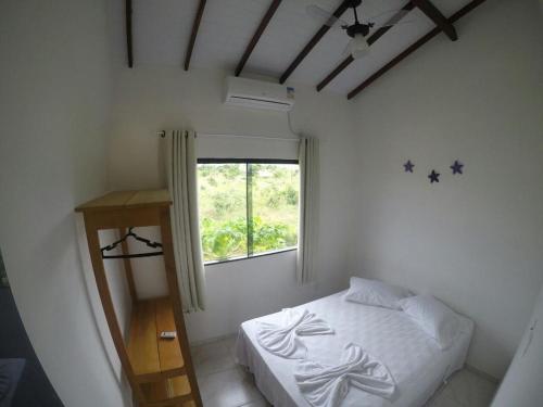 ein kleines Schlafzimmer mit einem Bett und einem Fenster in der Unterkunft Pousada Villas do Arraial in Arraial d'Ajuda