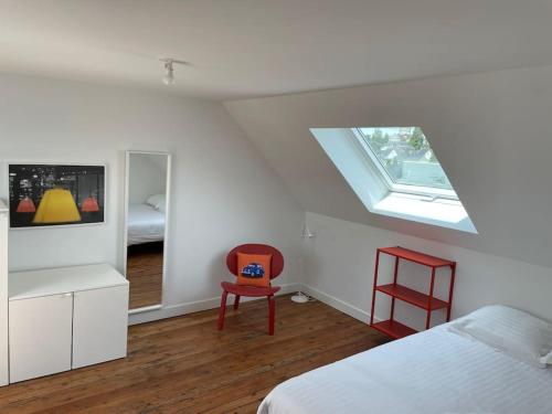 1 dormitorio con cama, ventana y silla en LA DOUCE Saumuroise en Angers