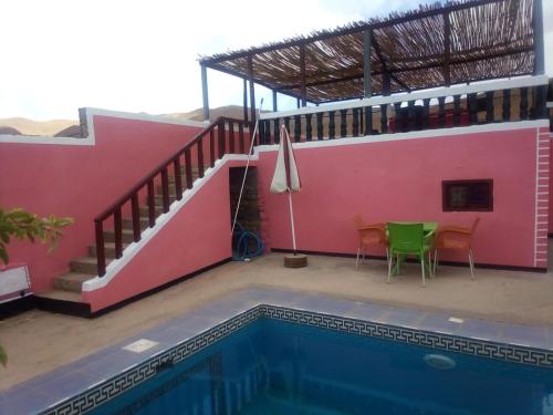 a house with a swimming pool next to a building at Riad Bouchra in Tamtetoucht
