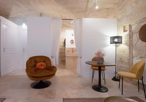 a living room with a chair and a table at La DAME de FLAUX in Uzès