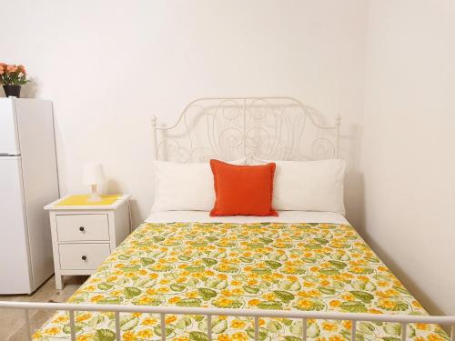 a bedroom with a bed with an orange pillow on it at Fiori e Frutti - Appartamento Economy in Almese