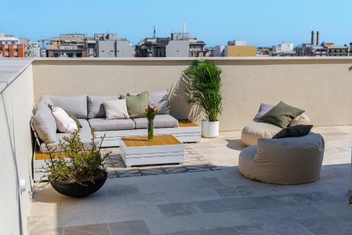a patio with couches and plants on a roof at HelloAPULIA Charming Palazzo Clemente - self-catering suites with aircondition in Monopoli