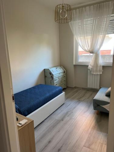 ein Schlafzimmer mit einem Bett, einer Kommode und einem Fenster in der Unterkunft Casa Marina Giardino delle Rose in Marina di Carrara