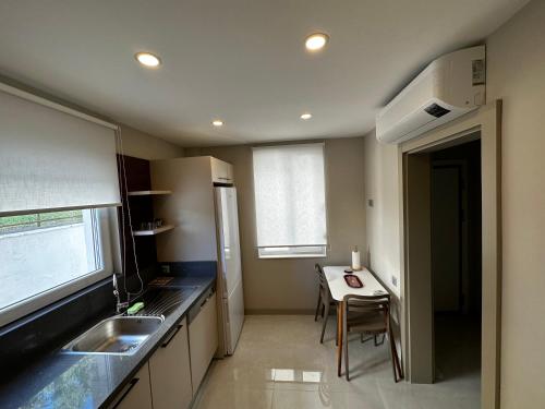 a small kitchen with a table and a sink at Side Holiday House in Side
