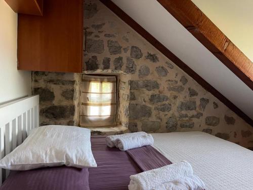 łóżko w pokoju z kamienną ścianą w obiekcie Villa FRIENDS w mieście Donji Morinj