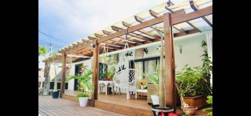 une maison avec une terrasse en bois agrémentée de plantes dans l'établissement Villa with pool close to the sea, à Saint-Gilles les Bains