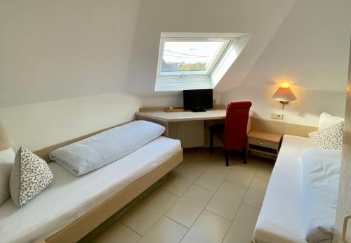 a room with a bed and a desk and a window at Hotel Alessandro in Neuried