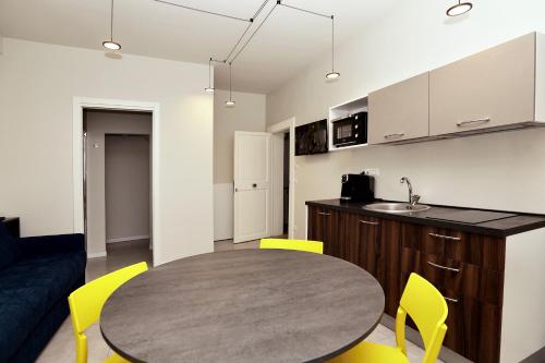 a kitchen and dining room with a table and yellow chairs at Casa Bomma in Messina