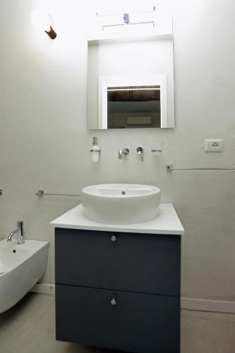 a white bathroom with a sink and a mirror at Casa Bomma in Messina