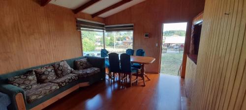 - un salon avec un canapé, une table et des chaises dans l'établissement Los aromos, à Lago Ranco