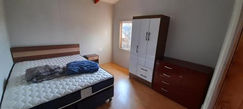 - une petite chambre avec un lit et une commode dans l'établissement Los aromos, à Lago Ranco