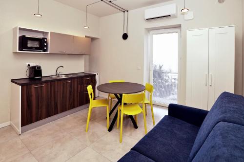 a kitchen and a living room with a table and chairs at Casa Bomma in Messina