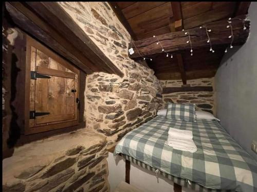 a room with a bed in a stone building at Las Casitas de Requeixo in Requeixo